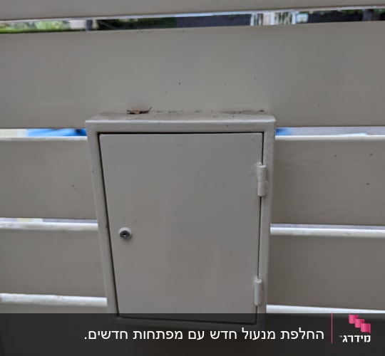 תיבת מתכת עם מנעול על גדר לבנה